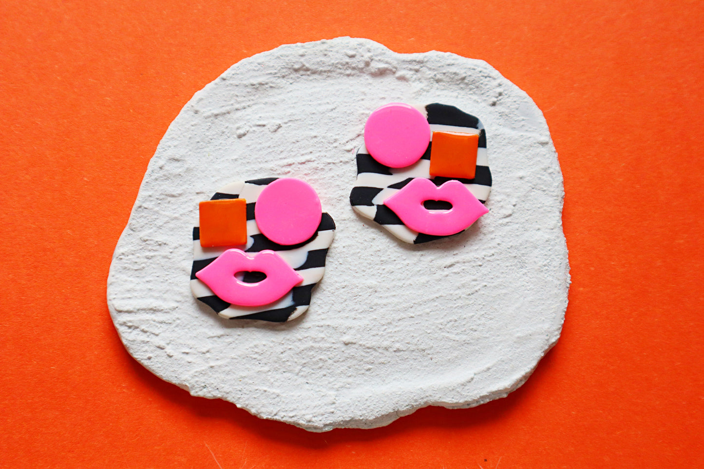 Avant-Garde Polymer Clay Abstract Faces Earrings: Black & White Checkered Background with Vibrant Pink and Orange Details- Unique polymer clay Studs