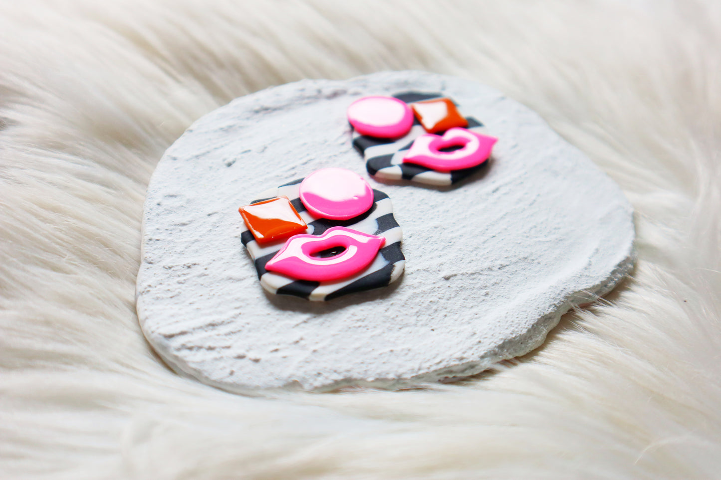 Boucles d’oreilles avant-gardistes en argile polymère avec visages abstraits : fond à carreaux noir et blanc avec détails roses et orange vifs - Clous uniques en argile polymère